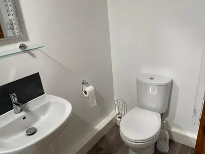 a white bathroom with a toilet and a sink at The Cow Shed - Sleeps 4 Parking & Pet Friendly in Bradwell on Sea