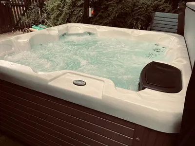 a jacuzzi tub sitting in a yard at Alfie Acres - Secluded Cabin set in 5 Acres of Privacy, with Exclusive use of Swimming Pool and Hot Tub for up to 10 Guests in Downham
