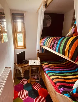 a room with two bunk beds and a desk with a laptop at Alfie Acres - Secluded Cabin set in 5 Acres of Privacy, with Exclusive use of Swimming Pool and Hot Tub for up to 10 Guests in Downham