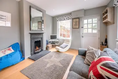 a living room with a blue couch and a fireplace at 6 West Lane in Aldeburgh - Beautiful cottage near high street in Aldeburgh