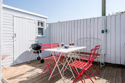 a table and chairs on a deck with a grill at 6 West Lane in Aldeburgh - Beautiful cottage near high street in Aldeburgh