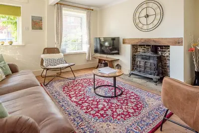 a living room with a couch and a fireplace at Abigail's Cottage, Wickham Market in Woodbridge