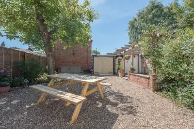 a wooden picnic table sitting in a garden at Abigail's Cottage, Wickham Market in Woodbridge