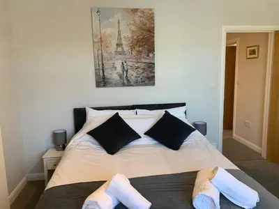a bedroom with a bed with slippers on it at Eclipse Apartment No 4 in Newmarket