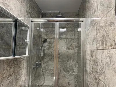a shower with a glass door in a bathroom at Eclipse Apartment No 4 in Newmarket