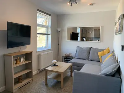 a living room with a couch and a tv at Eclipse Apartment No 4 in Newmarket