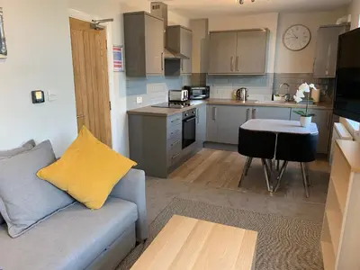 a living room with a couch and a kitchen at Eclipse Apartment No 4 in Newmarket