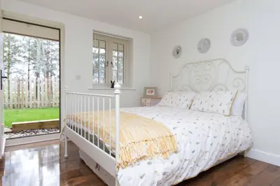a white bedroom with a white bed and a window at Breckland Cottage - Secluded Country Getaway in Hockwold cum Wilton