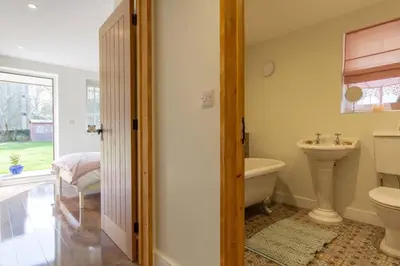 a bathroom with a sink and a toilet and a tub at Breckland Cottage - Secluded Country Getaway in Hockwold cum Wilton