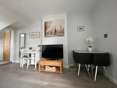 a living room with a table and a television and a table and chairs at Eclipse Apartment No 3 in Newmarket