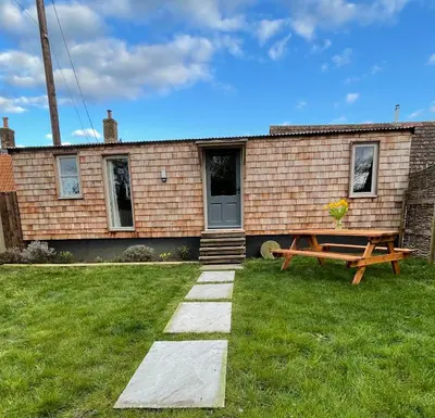 a house with a picnic table in front of it at Keepers Cottage in Ipswich