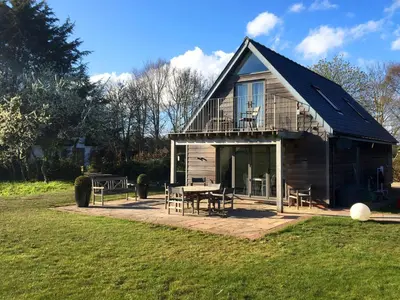 a house with a deck and a table in the yard at White Cottage Apartment in Snape