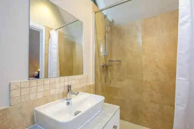 a bathroom with a sink and a shower at White Cottage Apartment in Snape