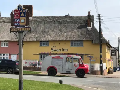 an ice cream truck parked in front of a building at The Swan Inn in Monks Eleigh
