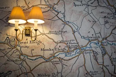 a light fixture on a wall with a map at The Swan Inn in Monks Eleigh