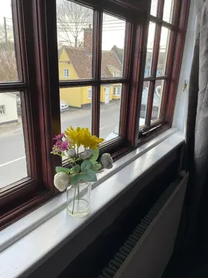 a vase of flowers sitting on a window sill at The Swan Inn in Monks Eleigh