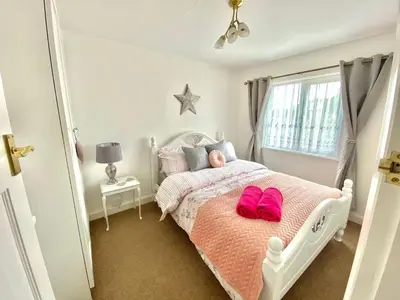 a bedroom with a bed with pink shoes on it at Cosy Cottage Great Bentley near station and shops in Great Bentley