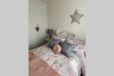 a bedroom with a bed with a star on the wall at Cosy Cottage Great Bentley near station and shops in Great Bentley