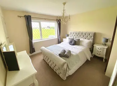 a bedroom with a large bed and a window at Cosy Cottage Great Bentley near station and shops in Great Bentley