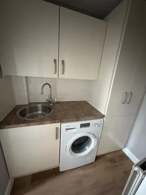 a kitchen with a sink and a washing machine at Cosy Cottage Great Bentley near station and shops in Great Bentley