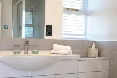 a white bathroom with a sink and a mirror at The Ferry Boat Inn in North Fambridge