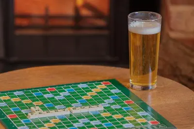 a glass of beer sitting on a table with a chessboard at The Ferry Boat Inn in North Fambridge