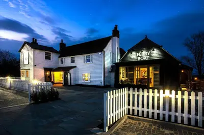 a white picket fence in front of a white house at The Ferry Boat Inn in North Fambridge