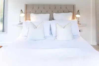 a white bed with white pillows on it at The Nook in West Mersea
