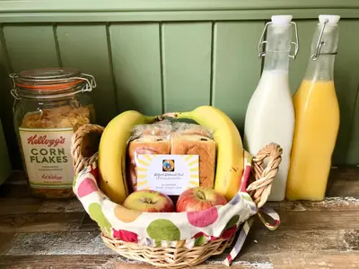 a basket of apples and bananas and bottles of milk at Melford Allotment Shed-Vintage Lodge Suffolk in Long Melford