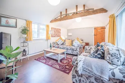a living room with a couch and a table at Suncatch Corner, Saxmundham in Saxmundham
