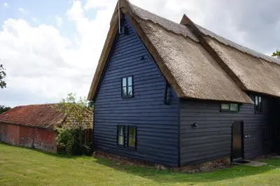 a blue house with a thatched roof at The Hayloft, Valley Farm, Snape in Saxmundham