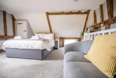a bedroom with two beds and a couch at The Hayloft, Valley Farm, Snape in Saxmundham