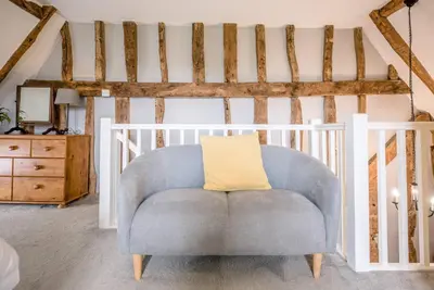 a blue chair in a room with a staircase at The Hayloft, Valley Farm, Snape in Saxmundham