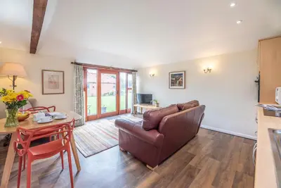 a living room with a couch and a table at The Stables, Valley Farm, Snape in Saxmundham