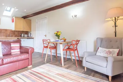 a living room with a couch and a table and chairs at The Stables, Valley Farm, Snape in Saxmundham