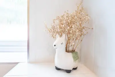 a white vase with flowers in it on a table at The Stables, Valley Farm, Snape in Saxmundham