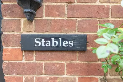 a sign on a brick wall with the word sticks at The Stables, Valley Farm, Snape in Saxmundham