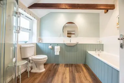 a bathroom with a toilet and a sink and a mirror at The Stables, Valley Farm, Snape in Saxmundham