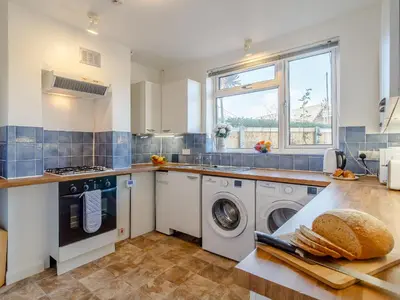 a kitchen with a washer and dryer on a counter at Mayflower Cottage in Harwich