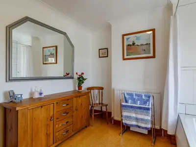 a bathroom with a wooden dresser and a mirror at Mayflower Cottage in Harwich