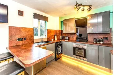 a large kitchen with stainless steel appliances and wooden counters at Elegant 2 BR Apartment in Historic Cambridge in Papworth Everard