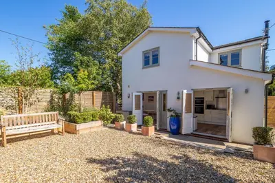 a white house with a bench in a yard at Yew Tree Cottage in Westleton