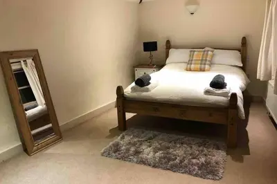 a bedroom with a bed with a mirror and a rug at Quirky 3 bedroom property in Wymondham