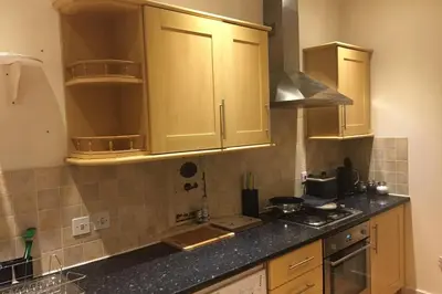 a kitchen with wooden cabinets and a counter top at Quirky 3 bedroom property in Wymondham