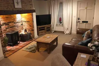 a living room with a couch and a fireplace at Quirky 3 bedroom property in Wymondham