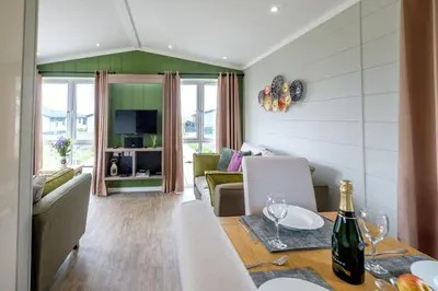 a dining room and living room with a table and chairs at Sea Cloud in Aldeburgh