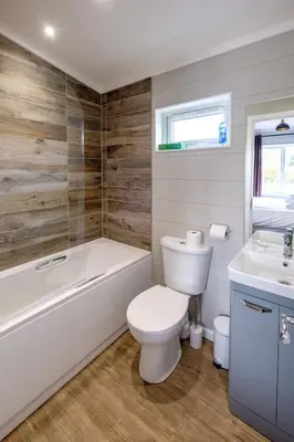 a bathroom with a toilet and a tub and a sink at Sea Cloud in Aldeburgh