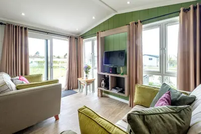 a living room with a couch and a tv at Sea Cloud in Aldeburgh