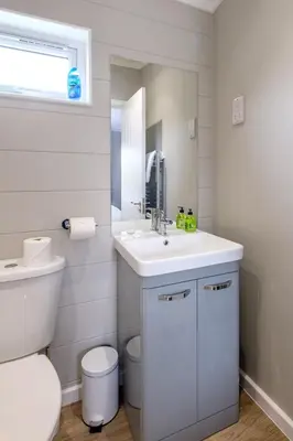 a white bathroom with a sink and a toilet at Sea Cloud in Aldeburgh