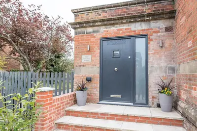 a black door on the side of a brick building at One The Old School, Leiston in Leiston